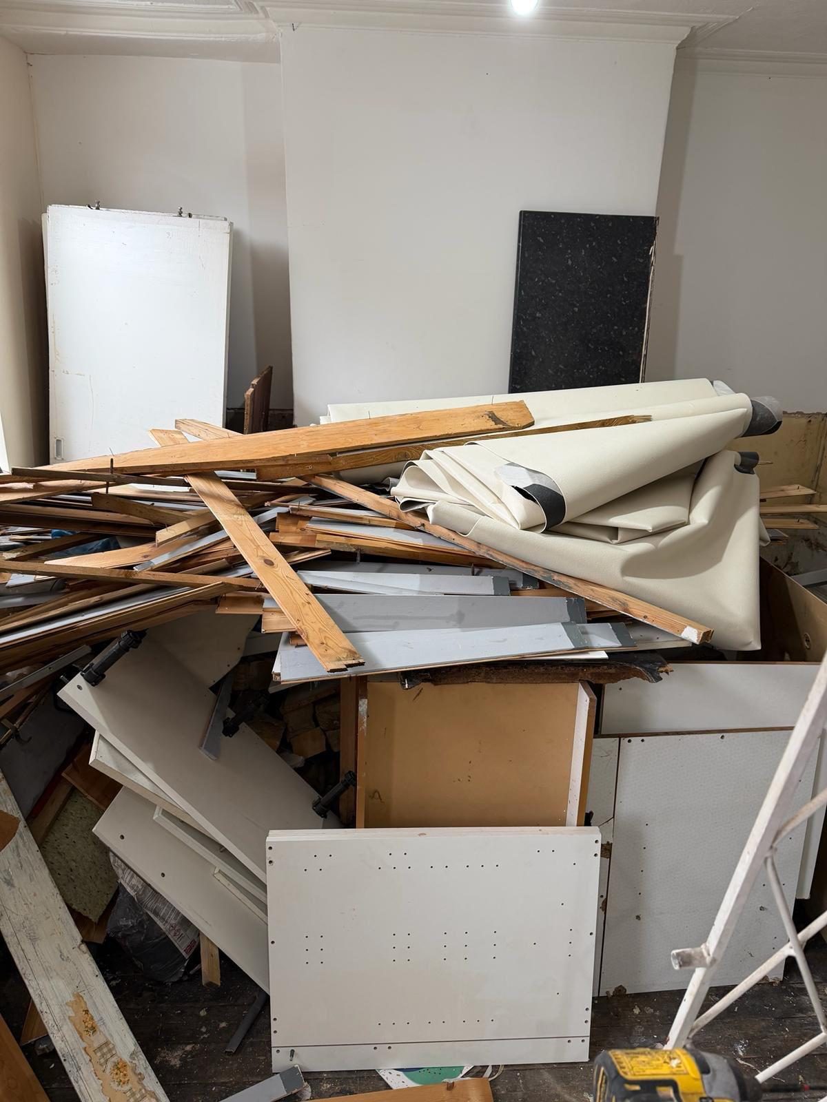 Dismantled cabinets and timber gathered during a property clearance